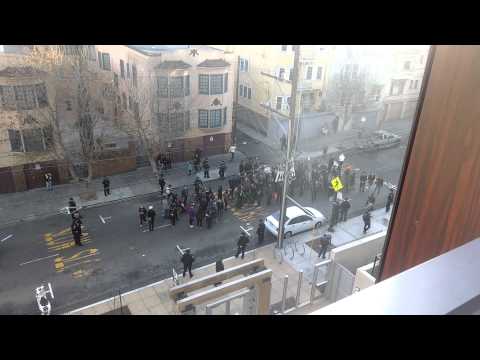 A resident films an anti-displacement protest from his balcony