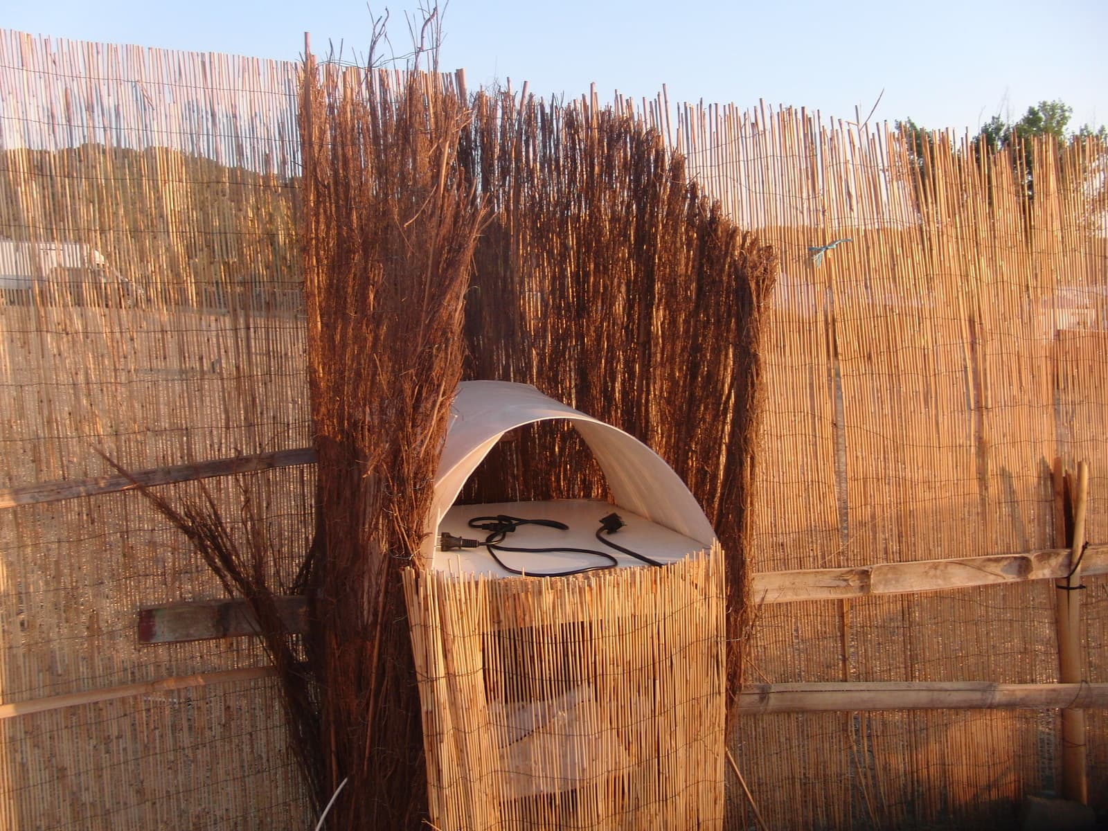 Compost toilet screened by reed fencing, Boom 2010