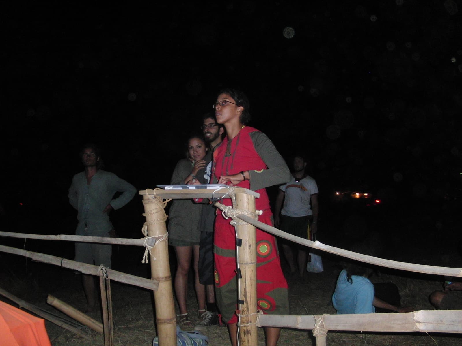 Speaker at a bamboo lectern after dark, Boom 2010