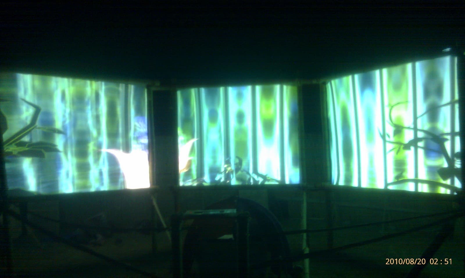 Green projection washing a long screen wall, Boom 2010