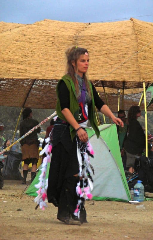 Performer in costume beside a cane shelter