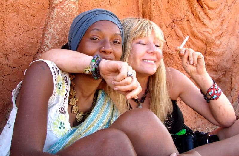 Two visitors resting against a painted wall