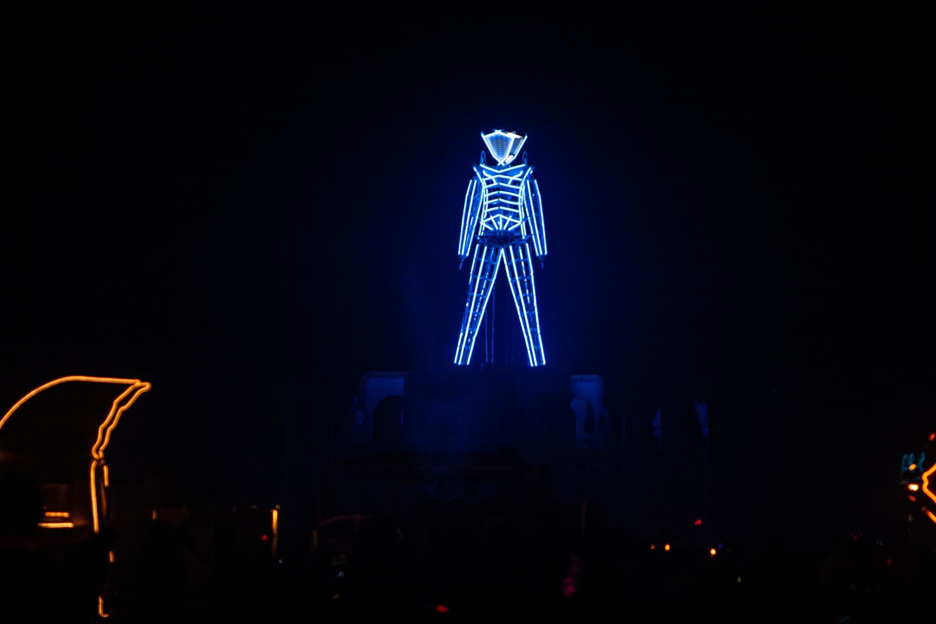 The blue-neon Man over the city · 4/5