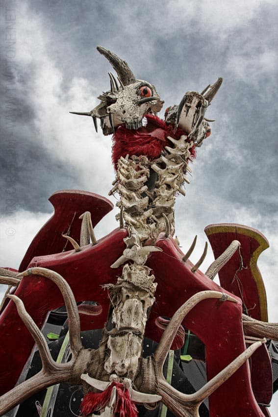 Skeletal dragon sculpture with red wings on art car