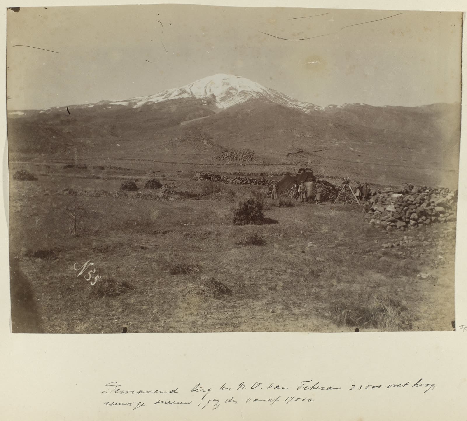Mount Damavand northeast of Tehran, with men working a tripod in the foreground