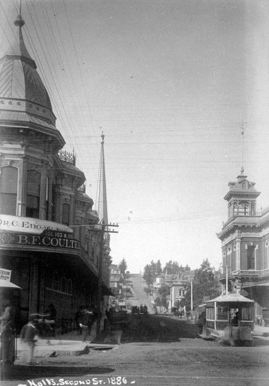 View west on 2nd at Spring; Hollenbeck Block when two stories (left), 2nd City Hall (rig…