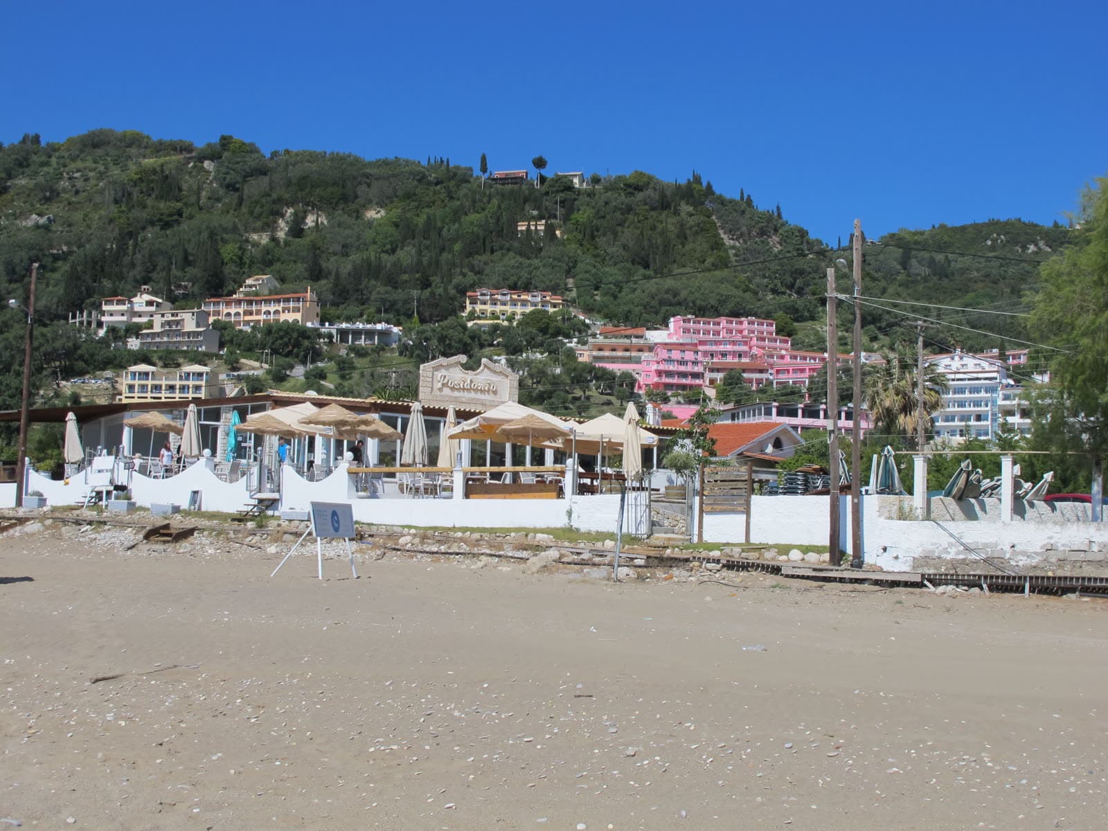 Agios Gordios beach with the coloured Pink Palace buildings visible on the hillside