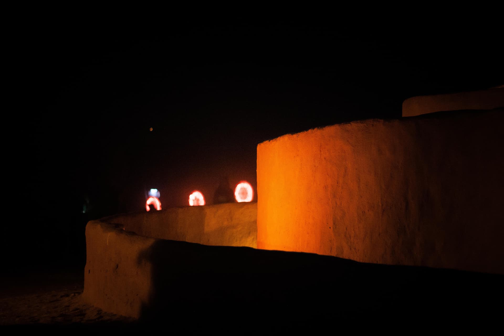 Lit doorway in an earth wall at night