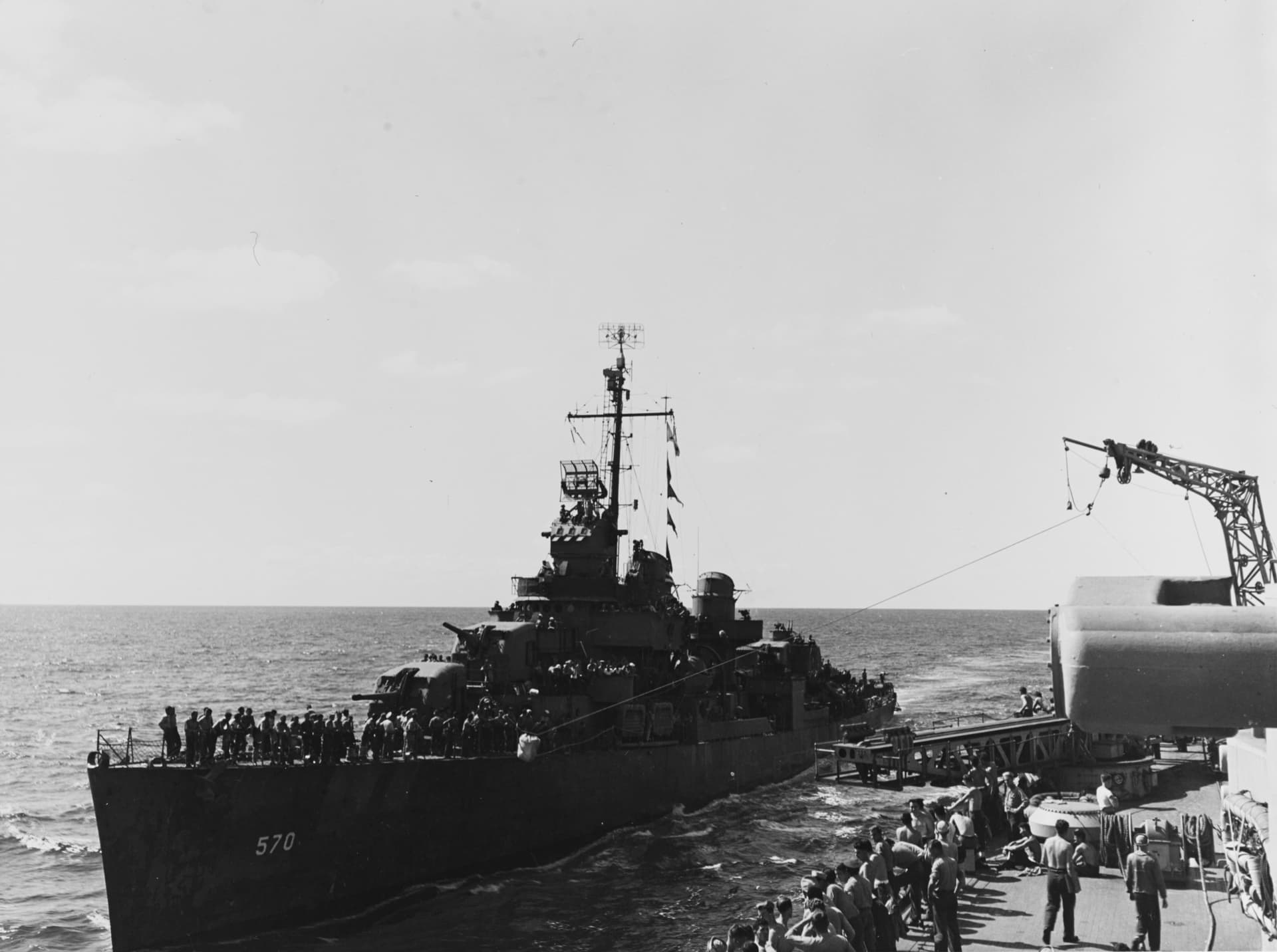 USS Charles Ausburne (DD-570) receiving mail from USS Columbia (CL-56) on 27 September 1943 ( )
