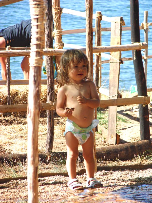 Child on a timber climbing frame by the lake