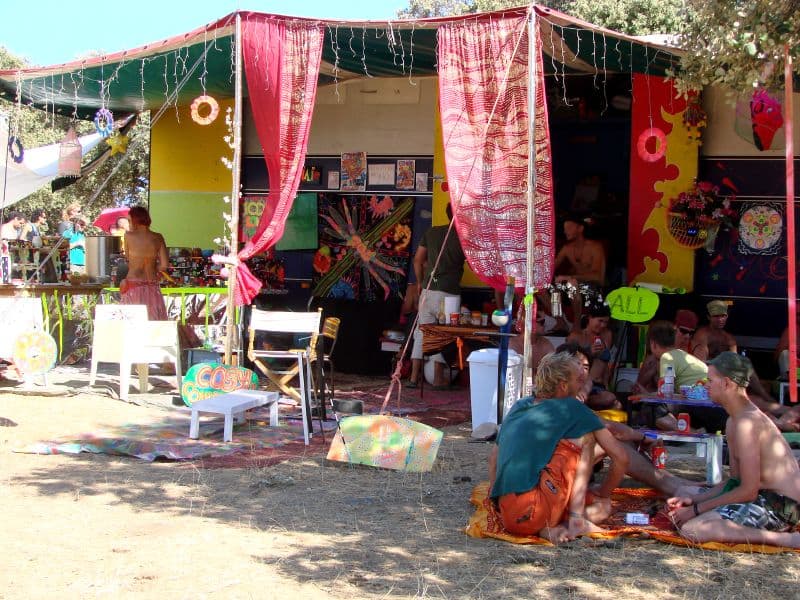 Textile hung stall with visitors seated outside