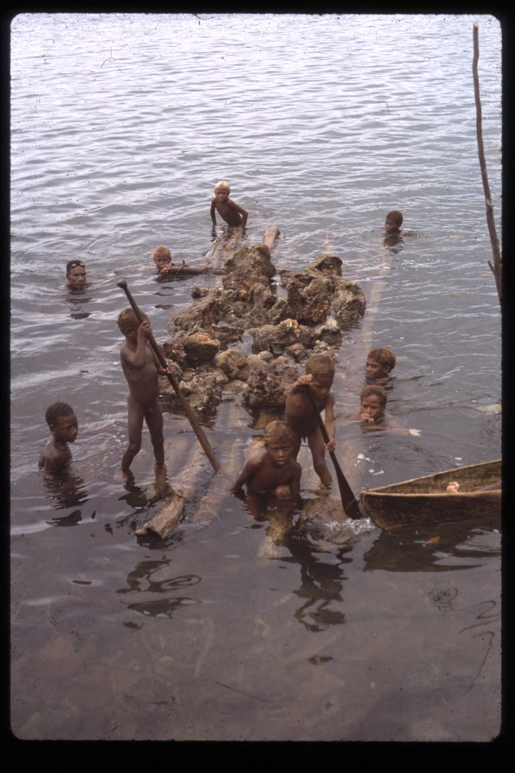 Children rafting coral blocks to build an island