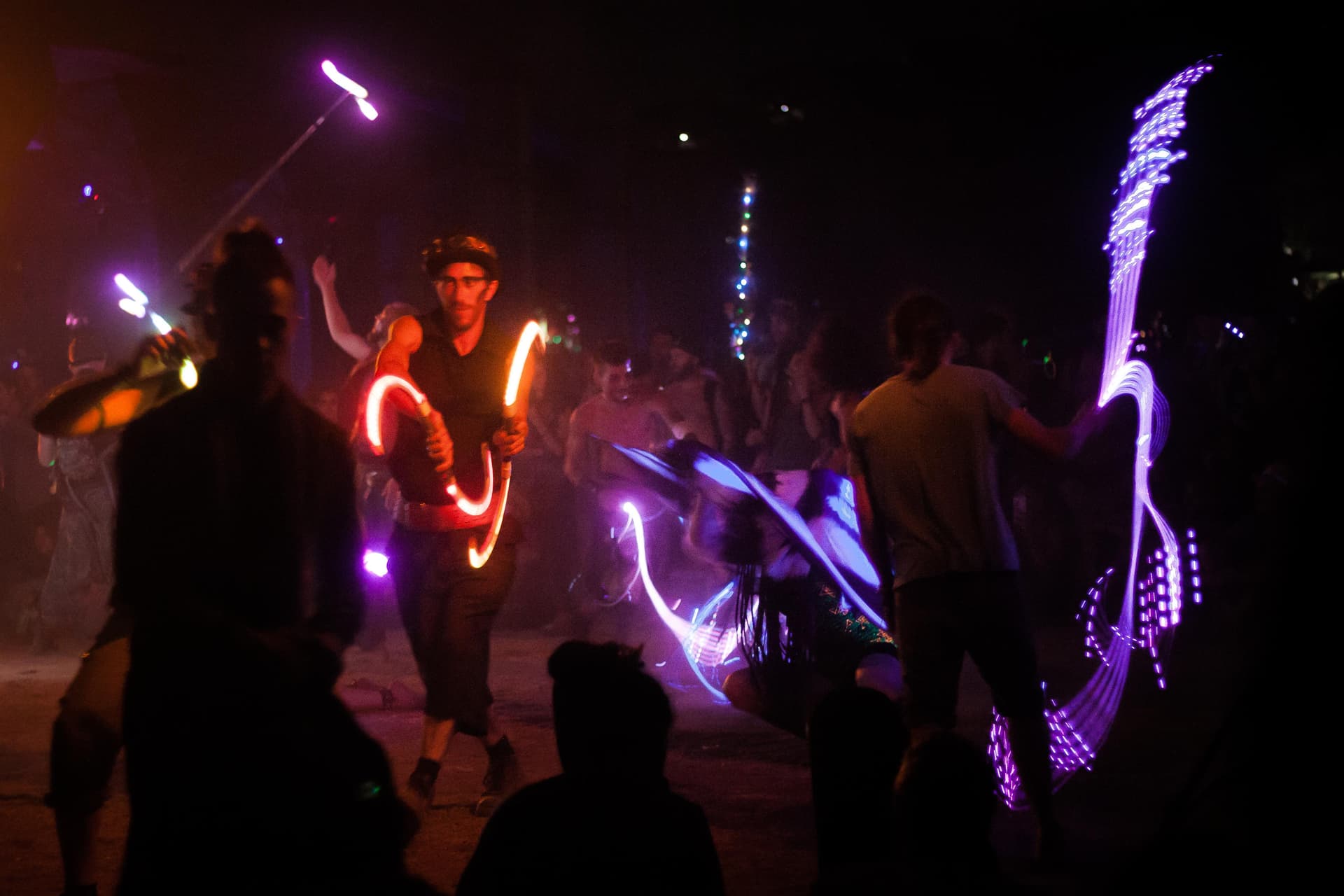 Lit performance props in the night crowd